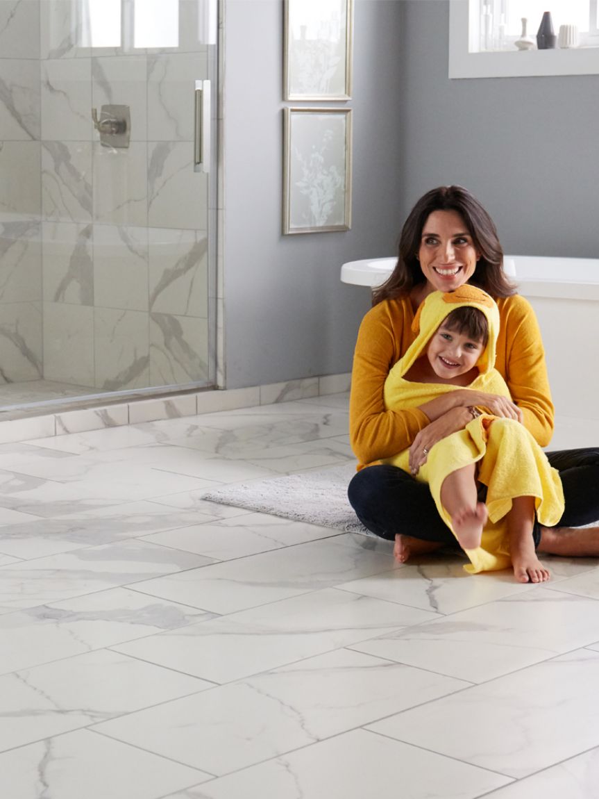 Woman sitting on hardwood floors with small dog next to her